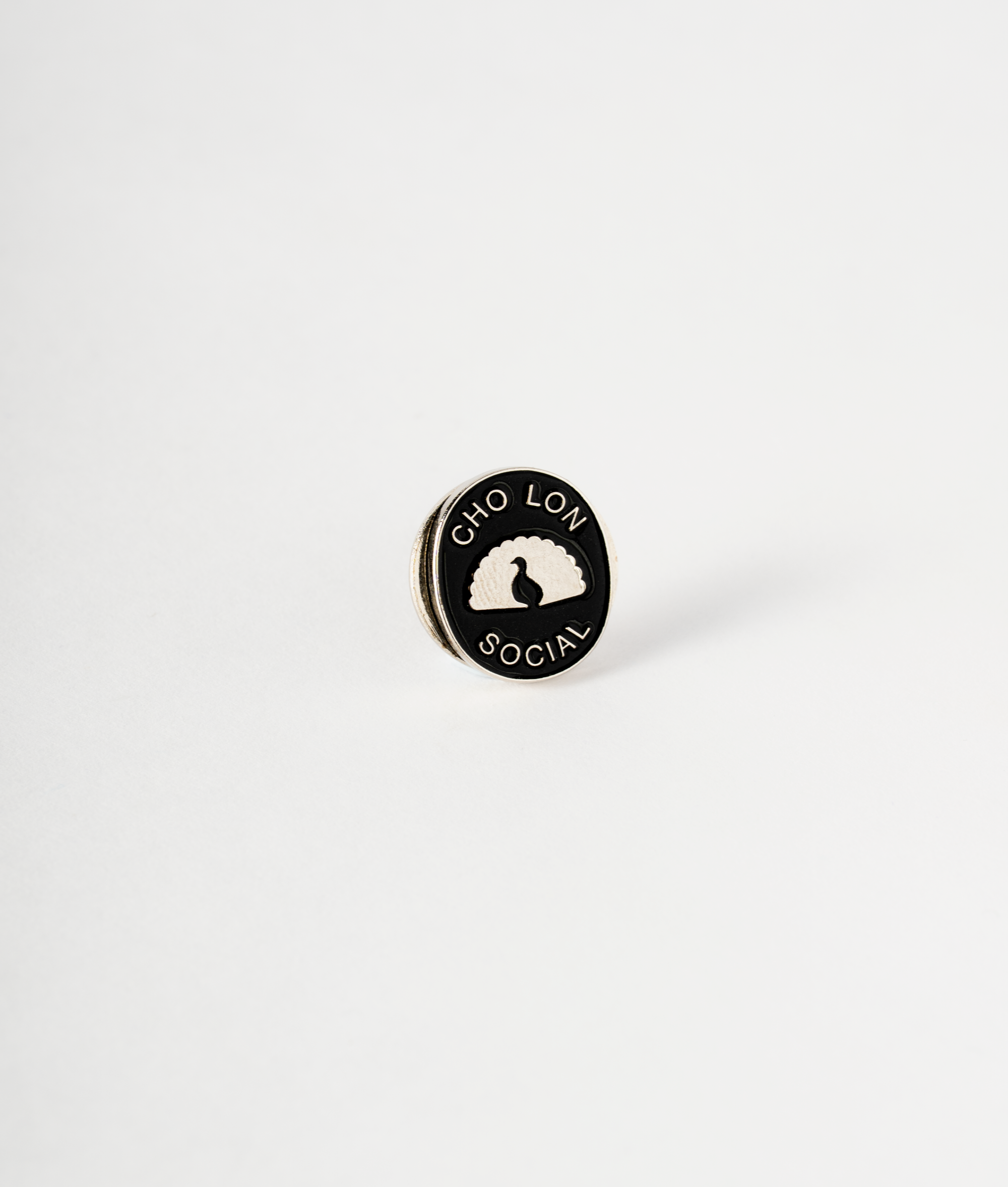 Round black and white pin with 'Cho Lon Social' text on a light gray background