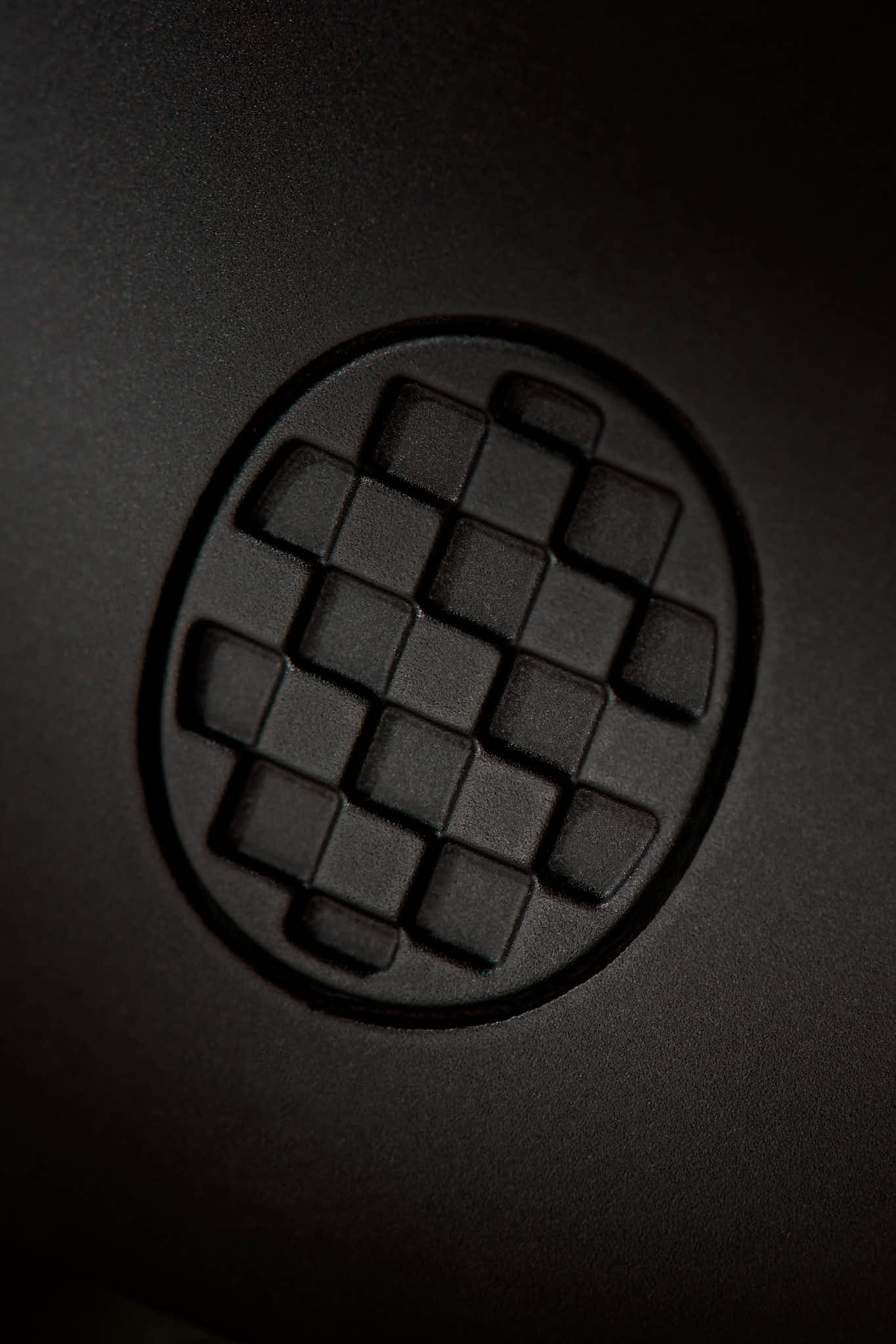 Close-up of a textured black surface with a circular pattern
